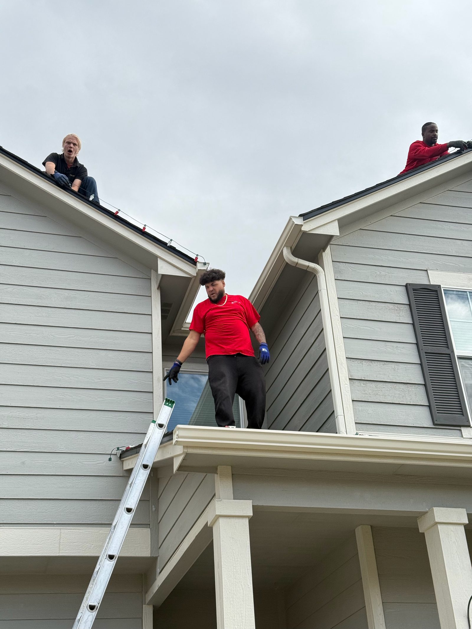 Our Front Range team installing multicolor Christmas lights along roof peaks Our Front Range team installing multicolor Christmas lights along roof peaks