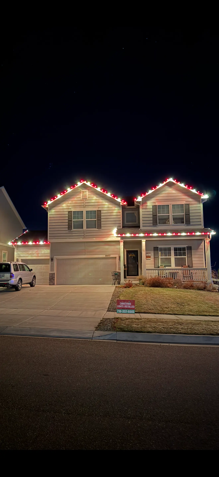 Front Range portfolio: red and white LED roofline and garage lights on a two-story home